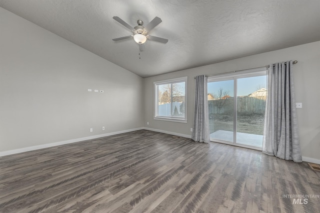 unfurnished room featuring vaulted ceiling, dark wood-type flooring, ceiling fan, and a textured ceiling