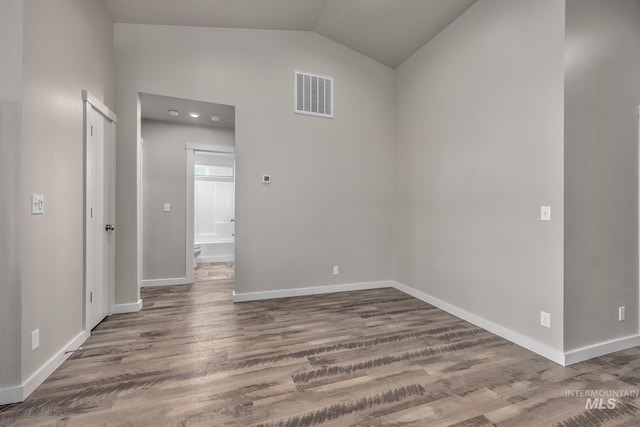 unfurnished room with lofted ceiling and wood-type flooring