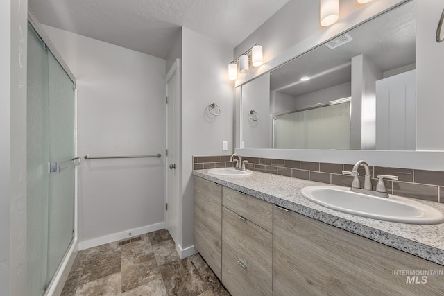 bathroom featuring tasteful backsplash, vanity, and an enclosed shower