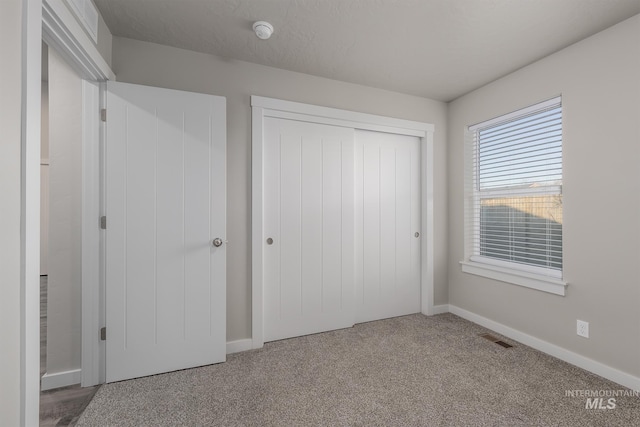 unfurnished bedroom with carpet flooring and a closet