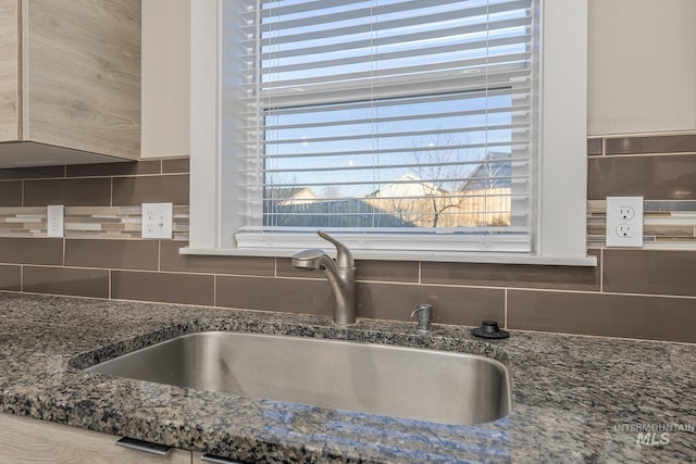 interior details with tasteful backsplash, sink, and stone counters