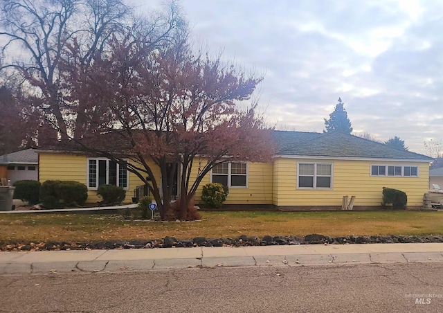 ranch-style home with a garage and a front yard