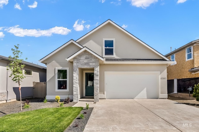 view of front of house with driveway, stone siding, and stucco siding