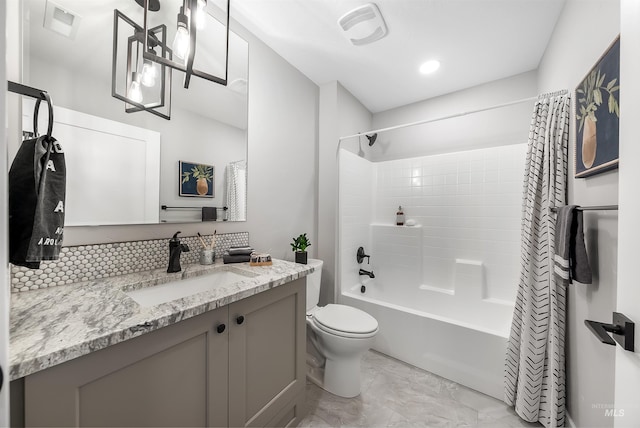 bathroom featuring toilet, vanity, visible vents, and shower / tub combo with curtain