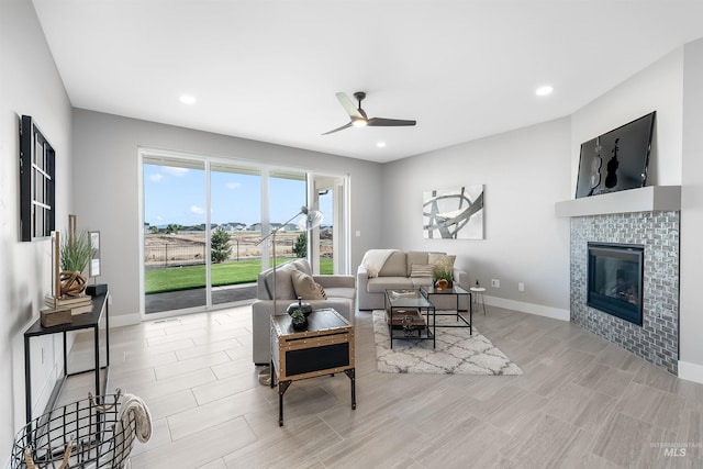 living area featuring ceiling fan, recessed lighting, a tile fireplace, and baseboards