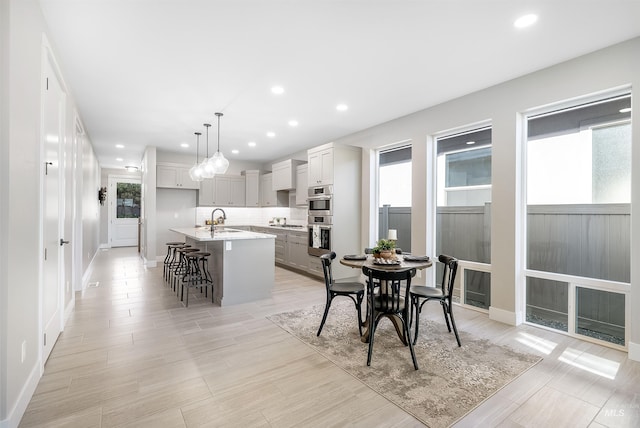 dining area with light wood-style floors, recessed lighting, and baseboards