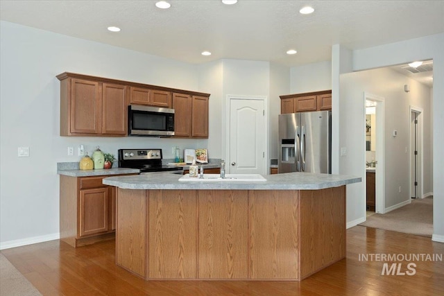 182 New Hampshire Way, Twin Falls, ID 83301 - kitchen featuring stainless steel appliances, wood finished floors, light countertops, a center island with sink, and recessed lighting