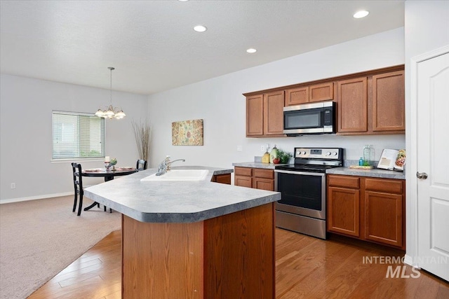182 New Hampshire Way, Twin Falls, ID 83301 - kitchen with appliances with stainless steel finishes, a sink, a chandelier, brown cabinets, and recessed lighting