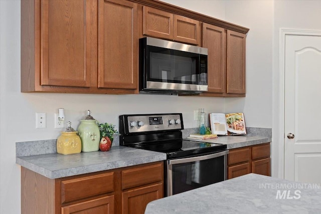 182 New Hampshire Way, Twin Falls, ID 83301 - kitchen featuring stainless steel appliances, brown cabinetry, and light countertops