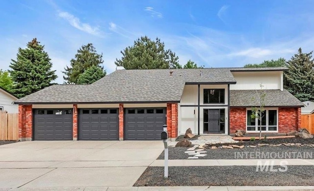 898 N Pebble Beach Way, Eagle, ID 83616 - view of front of property with an attached garage, concrete driveway, fence, roof with shingles, and brick siding