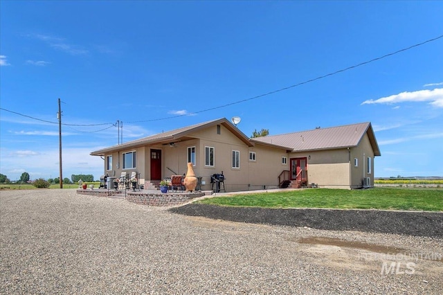 single story home with metal roof and a front lawn