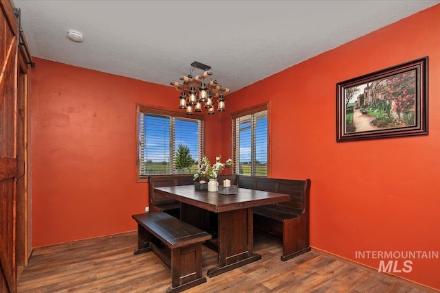 dining room featuring a chandelier, wood finished floors, and a textured ceiling