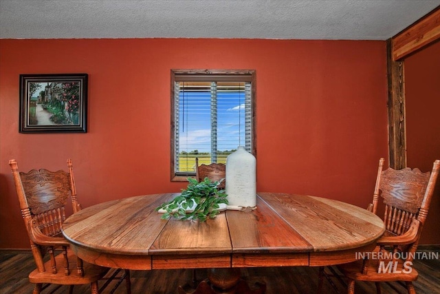dining space with a textured ceiling and wood finished floors