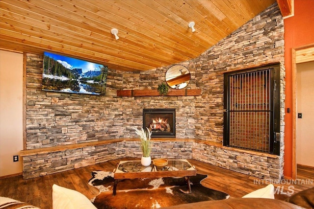 unfurnished living room with wooden ceiling, wood finished floors, lofted ceiling, and a stone fireplace
