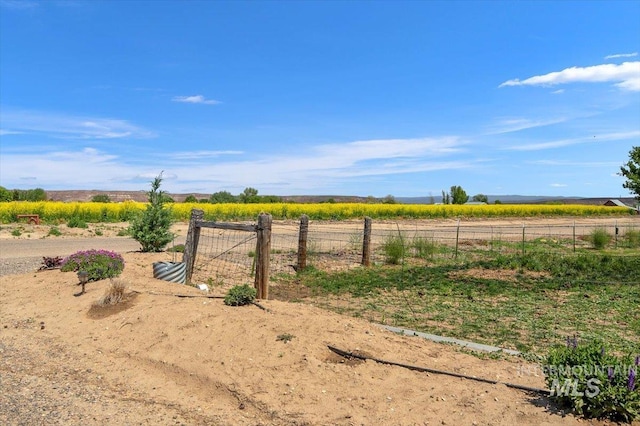 view of yard featuring fence and a rural view