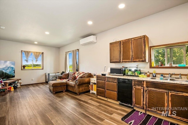 kitchen featuring stainless steel microwave, an AC wall unit, dark wood-style floors, black dishwasher, and a sink