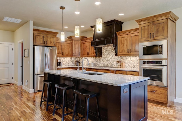 kitchen with decorative backsplash, visible vents, stainless steel appliances, and a sink