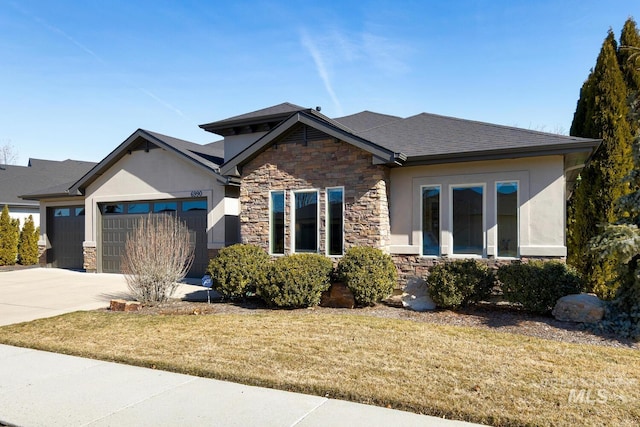 craftsman inspired home featuring stone siding, a front lawn, an attached garage, and driveway