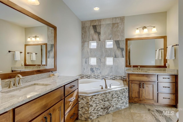 full bathroom with a garden tub, two vanities, and a sink