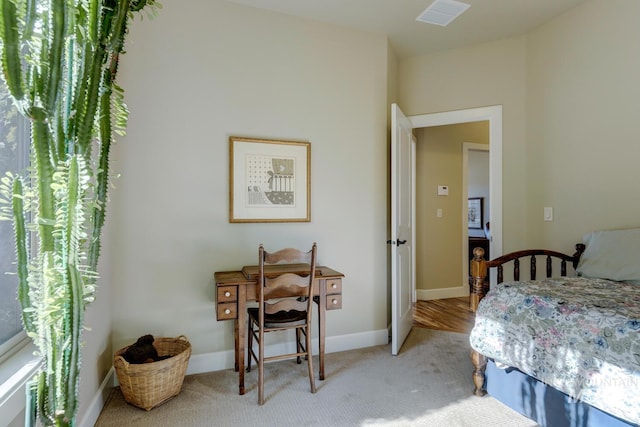 bedroom with baseboards, visible vents, and light colored carpet