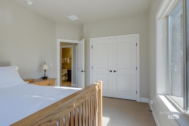 bedroom with light carpet, a closet, and baseboards