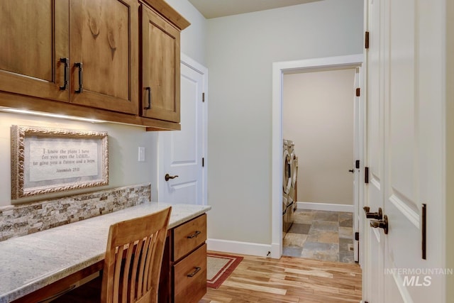 interior space featuring baseboards, brown cabinets, independent washer and dryer, light stone countertops, and light wood-style floors