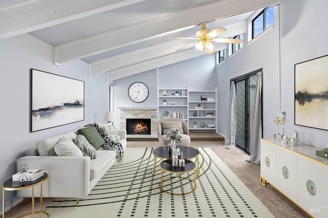 living room with carpet flooring, a tile fireplace, ceiling fan, and vaulted ceiling with beams