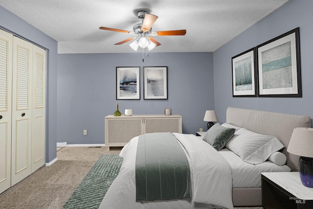 bedroom with ceiling fan, light colored carpet, a textured ceiling, and a closet