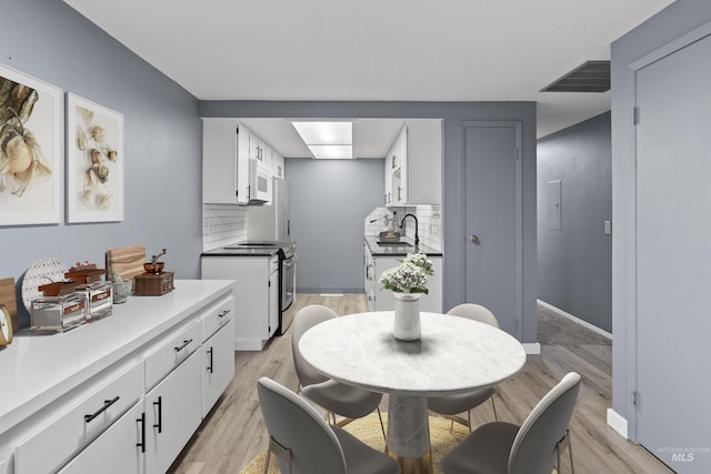 dining area with sink and light hardwood / wood-style flooring