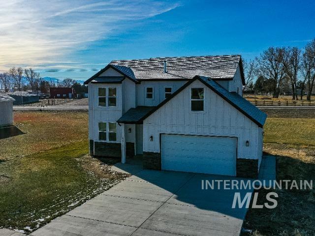 629 Manning Cir, Paul, ID 83347 - view of front facade featuring driveway, board and batten siding, a garage, and a front yard