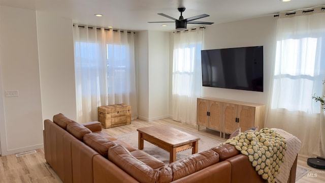 living room featuring ceiling fan and light hardwood / wood-style flooring