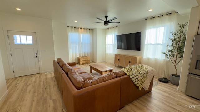 living room with ceiling fan and light hardwood / wood-style flooring