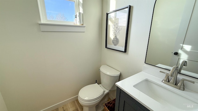 bathroom with hardwood / wood-style flooring, vanity, and toilet