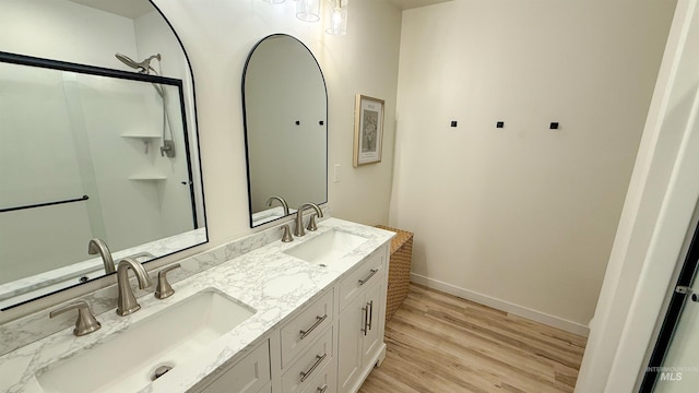 bathroom with vanity, hardwood / wood-style floors, and a shower with door