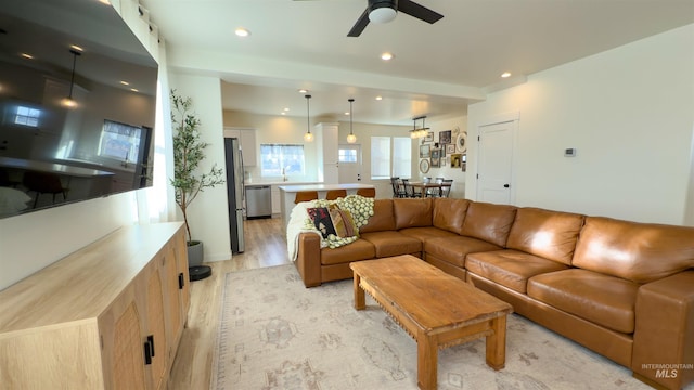 living room featuring ceiling fan and light hardwood / wood-style floors