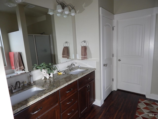 bathroom with hardwood / wood-style flooring, vanity, and a shower with shower door