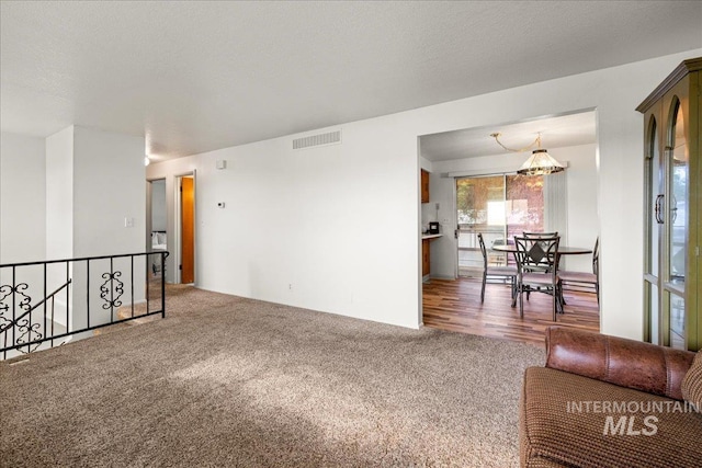 living room featuring dark colored carpet and a textured ceiling