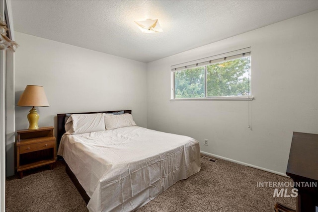 bedroom with a textured ceiling and carpet