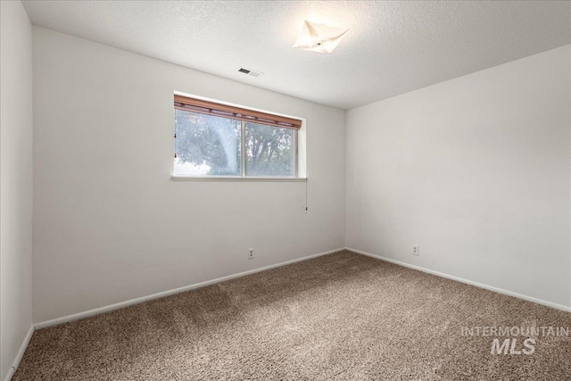 unfurnished room with carpet flooring and a textured ceiling