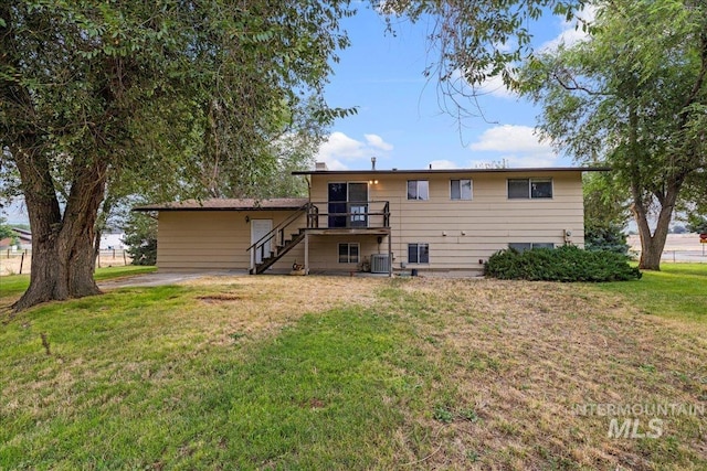 back of property with a lawn and central AC unit