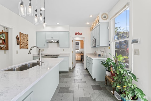 1416 N 13th St, Boise, ID 83702 - kitchen featuring light stone counters, a sink, stone finish floor, stainless steel microwave, and under cabinet range hood