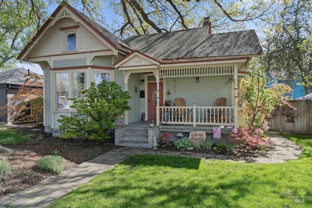 1416 N 13th St, Boise, ID 83702 - victorian home with fence, a chimney, a porch, and a front lawn
