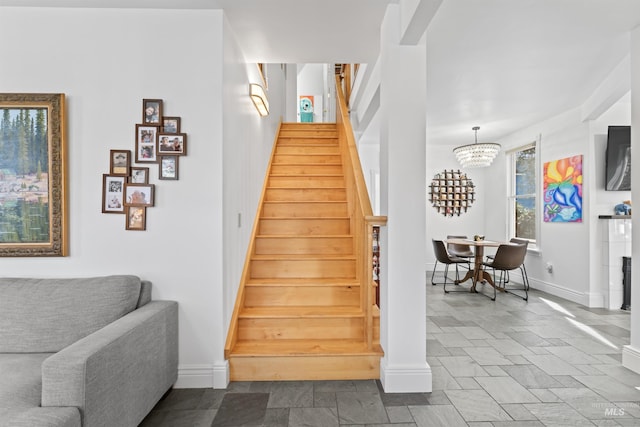 1416 N 13th St, Boise, ID 83702 - stairway with baseboards, a chandelier, and stone tile flooring