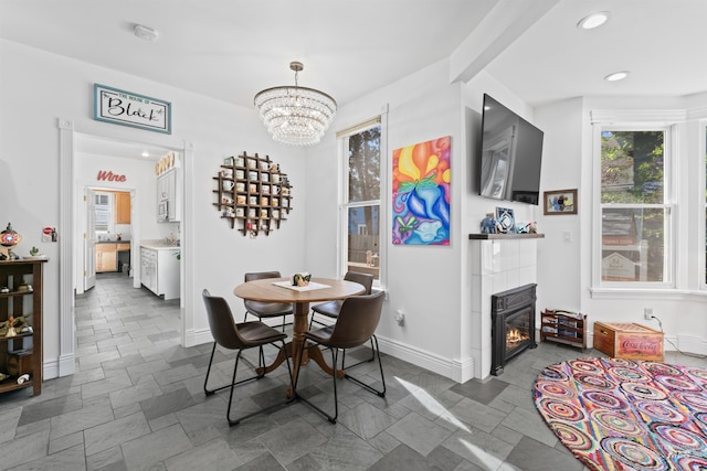 1416 N 13th St, Boise, ID 83702 - dining room with baseboards, stone finish floor, recessed lighting, a tile fireplace, and a notable chandelier