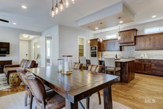 dining area featuring sink, a wealth of natural light, and light hardwood / wood-style flooring