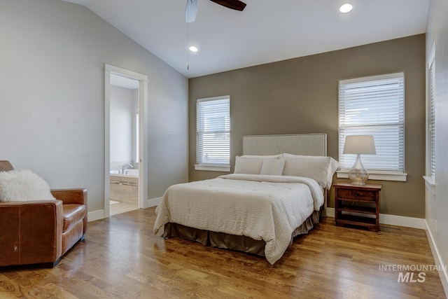 bedroom with ceiling fan, wood-type flooring, connected bathroom, and vaulted ceiling