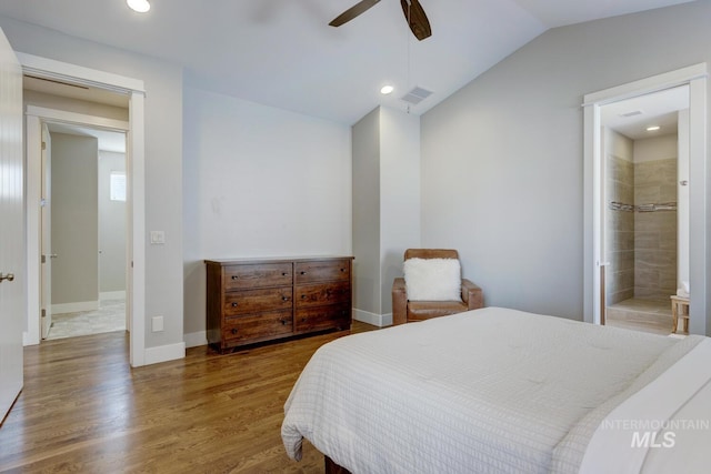 bedroom with ceiling fan, ensuite bath, lofted ceiling, and dark hardwood / wood-style flooring