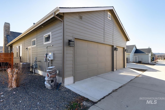 view of home's exterior with a garage and central air condition unit