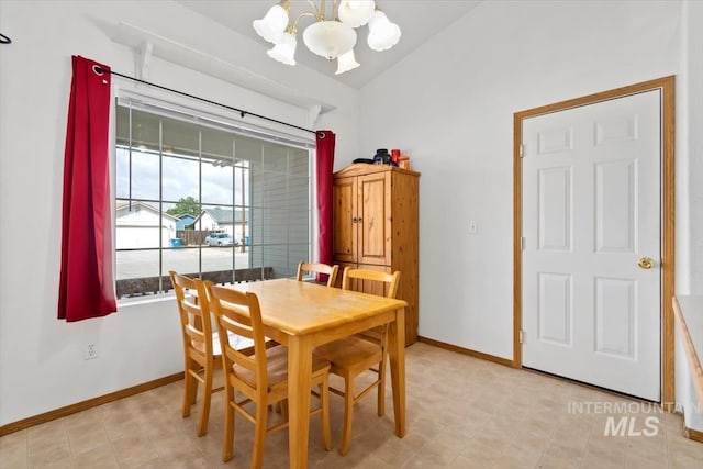 dining room with a notable chandelier and lofted ceiling