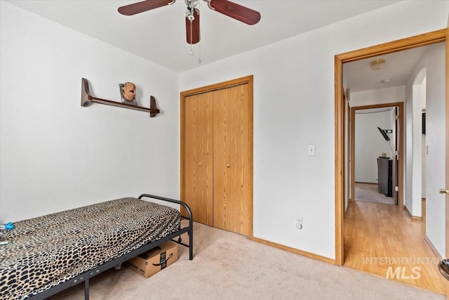 bedroom with ceiling fan, a closet, and light hardwood / wood-style flooring